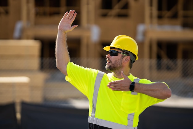 Travailleur soulignant le constructeur dans un casque travaillant sur un projet de construction sur un chantier de construction