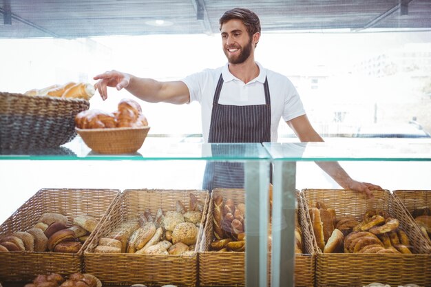 Travailleur souriant, posant derrière le comptoir