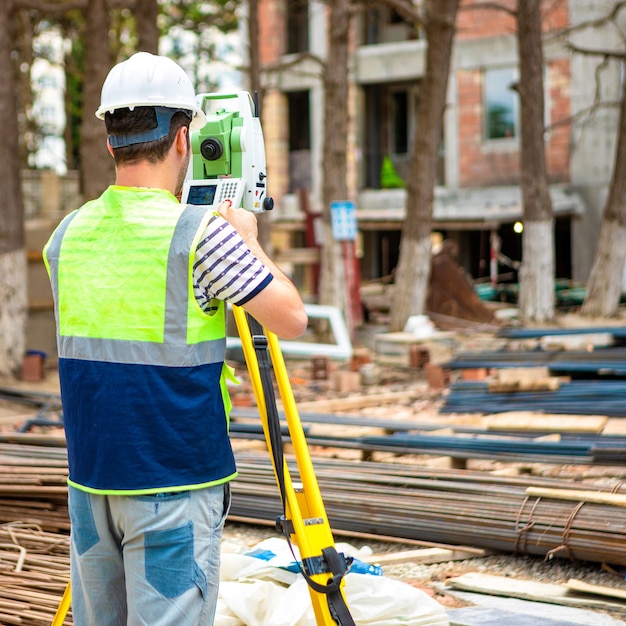 Travailleur de la topographie de la construction sur le chantier