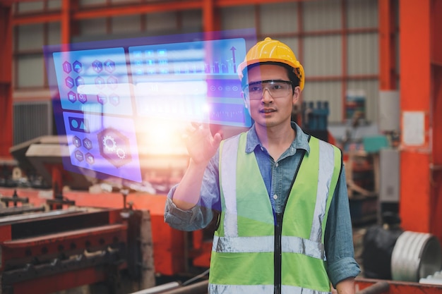 Travailleur utilisant l'écran visuel de la technologie vérifiant la sécurité du système avant de travailler dans l'usine de production