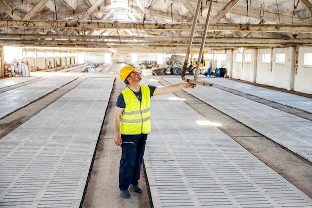 Un travailleur vérifiant la construction métallique au plafond sur le chantier de construction