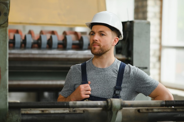 Travailleur en vêtements de protection en usine à l'aide d'une machine