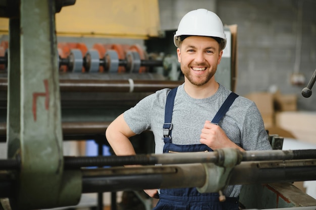 Travailleur en vêtements de protection en usine à l'aide d'une machine