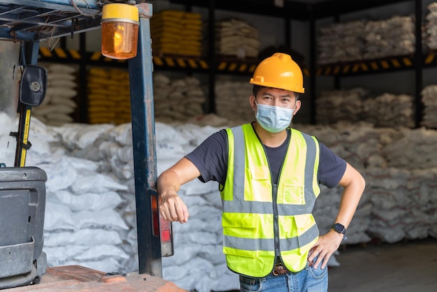 Les travailleurs des chariots élévateurs portent des masques de protection dans un entrepôt de produits chimiques