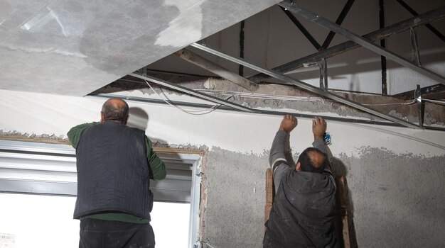 Travailleurs de la construction assemblant un plafond suspendu