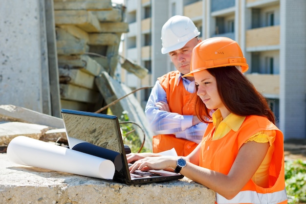 Travailleurs de la construction, femmes et hommes, regardant ordinateur portable et smili