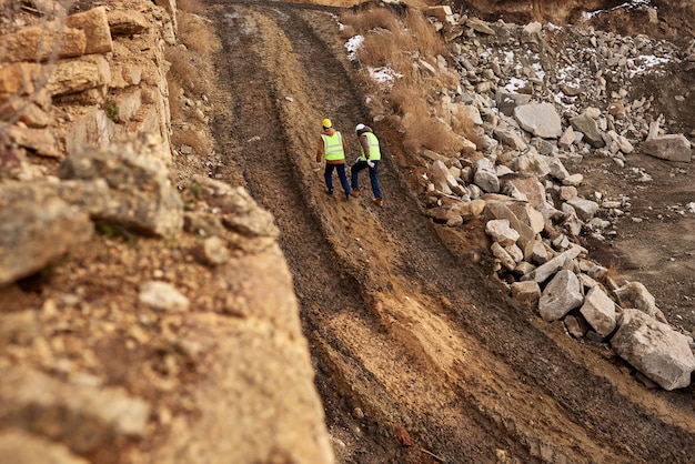 Travailleurs de la construction marchant dans la terre sur le site