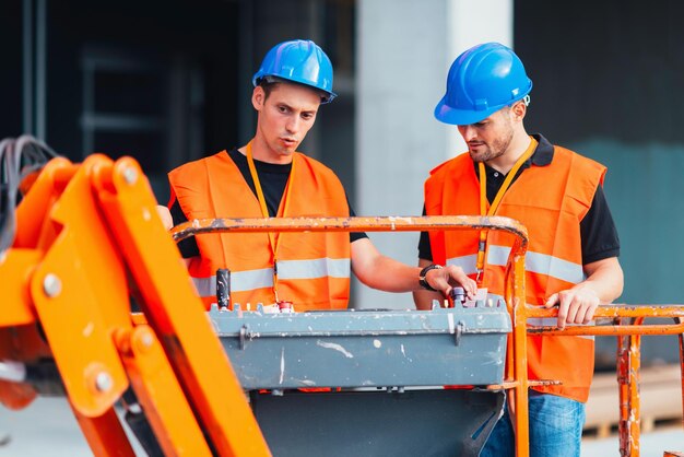 Travailleurs de la construction opérant sur une machine de construction