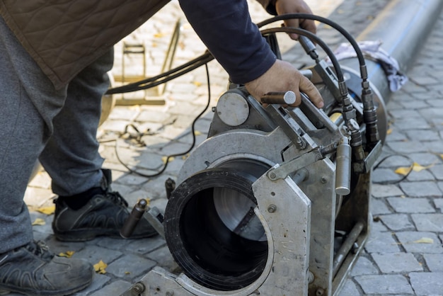 Travailleurs de la construction de services publics à connecter le tuyau HDPE dans la route de reconstruction