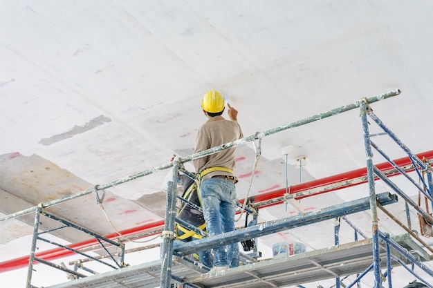 Photo travailleurs de la construction de la tour d'échafaudage peinture et rénovation de plancher du bâtiment