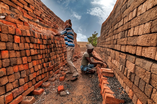 Des travailleurs indiens organisent des briques prêtes à l'emploi dans l'usine.