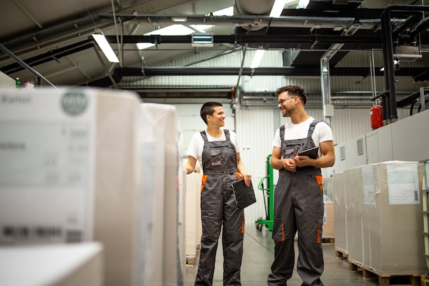 Travailleurs industriels debout dans une usine de fabrication de papier.