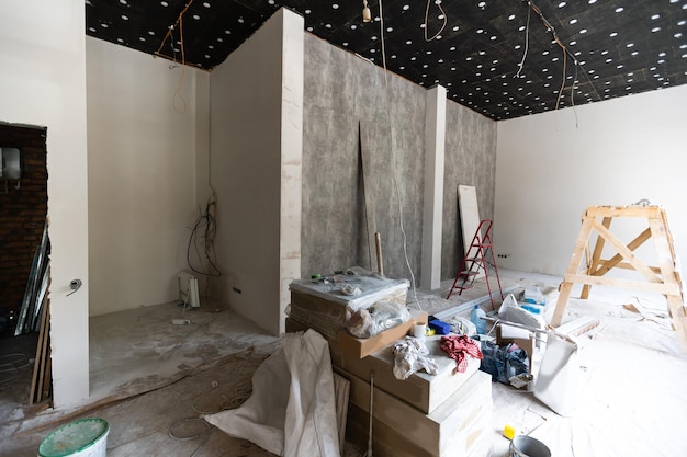 Les travailleurs installent des plaques de plâtre pour les murs de gypse dans l'appartement en cours de construction, de rénovation, de rénovation, d'extension, de restauration et de reconstruction