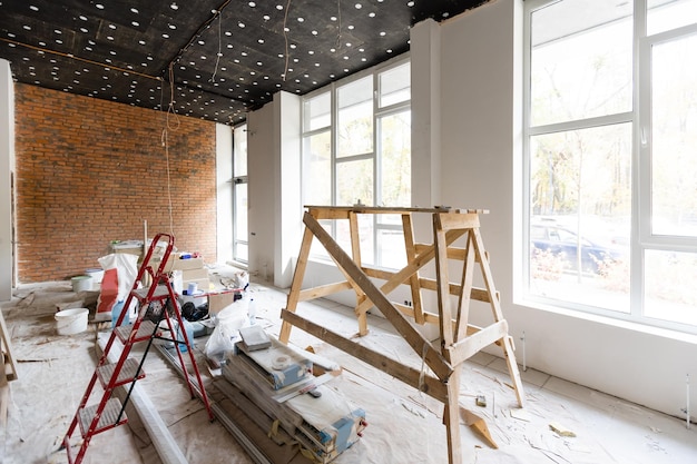 Les travailleurs installent des plaques de plâtre pour les murs de gypse dans l'appartement en cours de construction, de rénovation, de rénovation, d'extension, de restauration et de reconstruction
