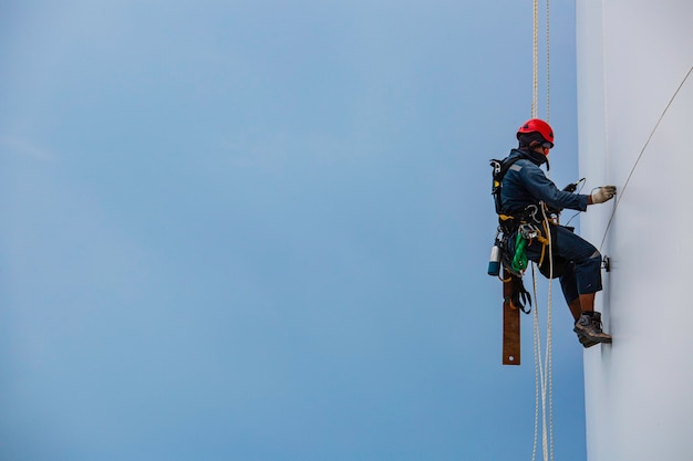 Travailleurs masculins en bas de la hauteur de l'accès par corde au réservoir inspection de l'épaisseur de la plaque de coque du réservoir de stockage du gaz propane travail de sécurité en hauteur.