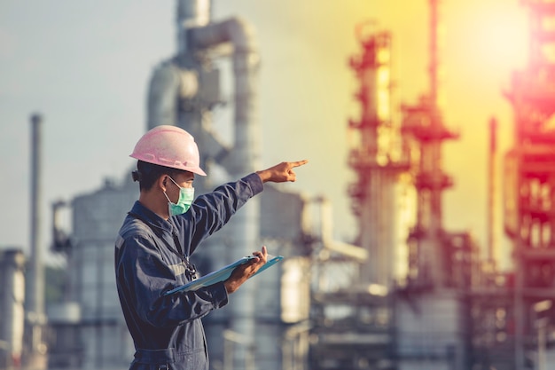 Les travailleurs masculins inspectent et enregistrent la raffinerie de processus sur le site de construction industrielle de pétrole et de gaz.