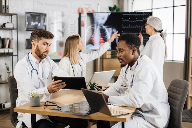 Photo travailleurs médicaux avec des gadgets se réunissant à la clinique