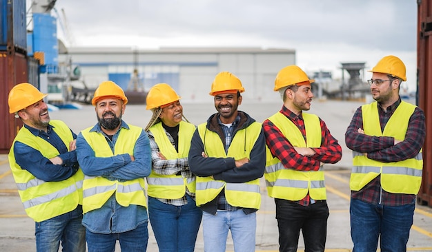 Travailleurs multiraciaux souriant devant la caméra tout en travaillant au port d'expédition en plein air Concept de logistique de fret et d'expédition de conteneurs Se concentrer sur les visages des personnes du centre