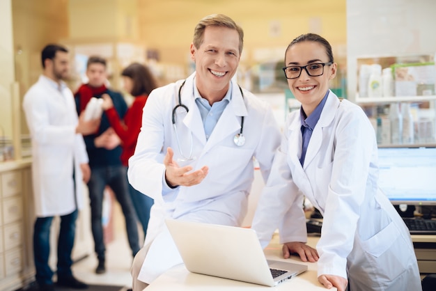 Les travailleurs de la pharmacie en blouse blanche posant sur la caméra.