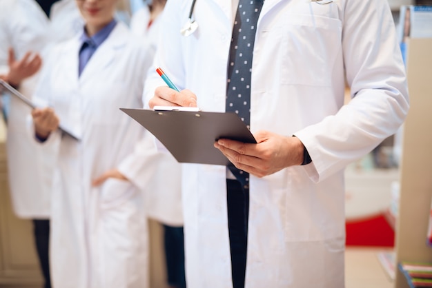 Les travailleurs de la pharmacie en blouse blanche posant sur la caméra.