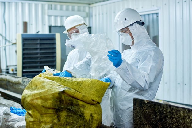 Les travailleurs trient le plastique sur l'usine de recyclage des déchets