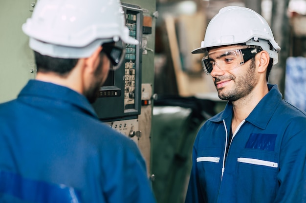 Les travailleurs d'usine aiment travailler ensemble avec un ami souriant heureux d'enseigner et d'apprendre à la machine de travail.