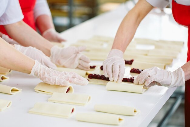 Les travailleurs de l'usine de confiserie préparent des desserts fourrés