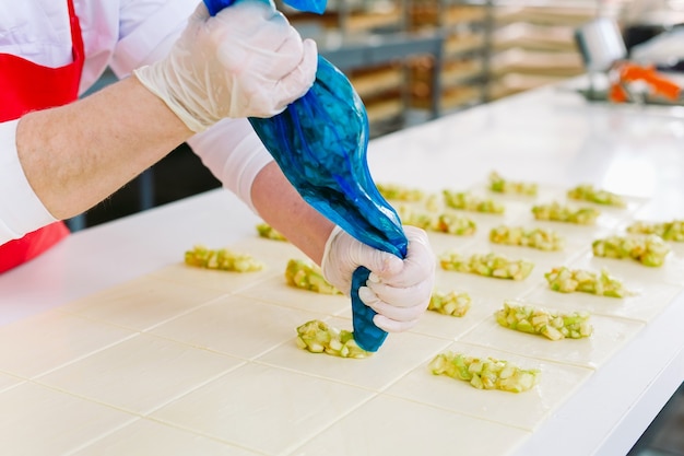 Les travailleurs de l'usine de confiserie préparent des desserts fourrés