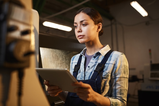 Travailleuse à l'aide de tablet pc dans l'usine