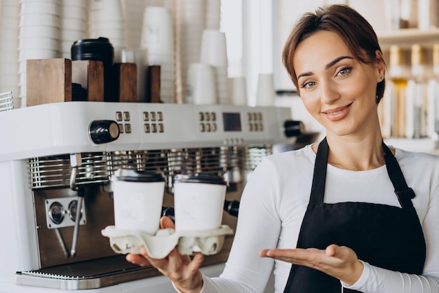 Travailleuse barista dans un café tenant une tasse de café