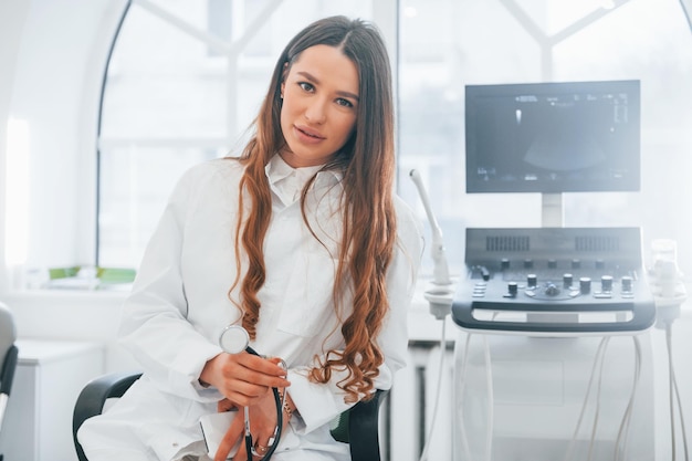 Une travailleuse clinique professionnelle en blouse blanche est à l'intérieur dans l'armoire