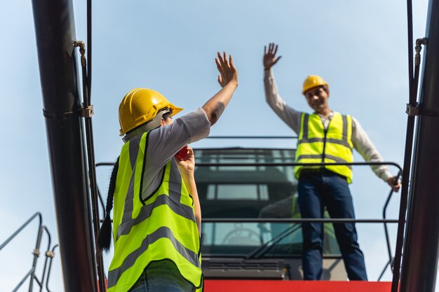 Une Travailleuse Debout Et Portant Un Casque Jaune Contrôle Le Chargement Et Vérifie La Qualité Des Conteneurs Du Cargo Cargo Pour L'importation Et L'exportation D'expédition