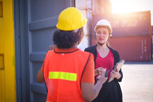 Travailleuse d'équipe Femmes américaines Travailler dans une zone de chantier maritime international Service de livraison d'exportation et d'importation avec des conteneurs