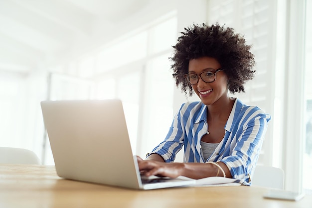 Travailleuse indépendante et l'aime totalement Photo recadrée d'une jeune femme travaillant sur son ordinateur portable à la maison