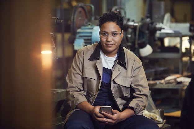 Travailleuse souriante posant à l'usine