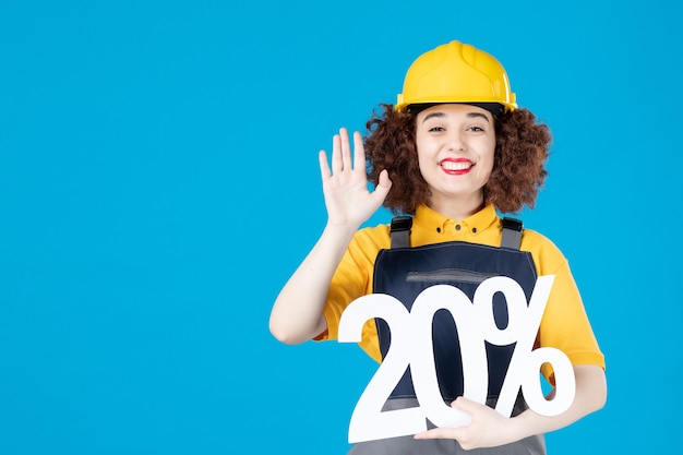 Travailleuse en uniforme jaune avec signe sur bleu