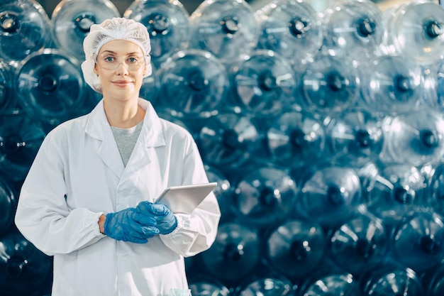 travailleuses travaillant dans une usine d'eau potable vérifiant le nombre de gallons de bouteilles d'eau dans l'entrepôt