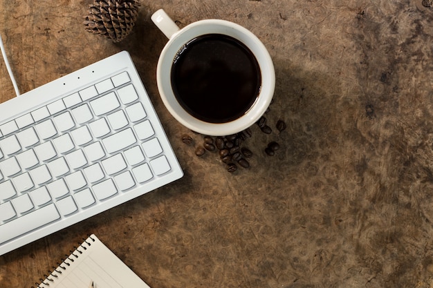 Travaillez Avec Le Clavier Et Posez Une Tasse De Café Sur Le Plancher En Bois.