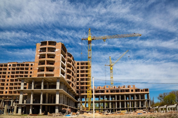 Travaux en cours sur un nouveau bloc d'appartements Grand bâtiment en construction avec des grues Chantier de construction du nouveau bâtiment