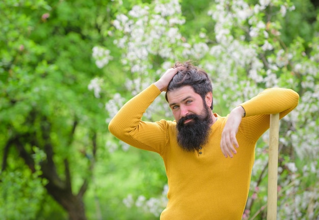 Travaux de jardinage agricole dans les plantes de jardin homme souriant se préparant à planter des travaux de jardinier travaux de printemps dans