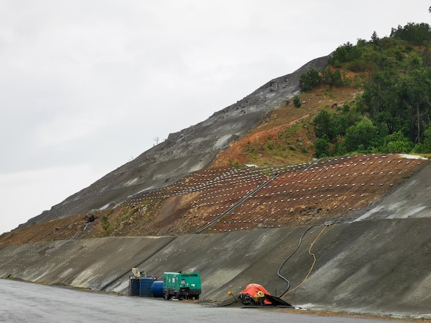 Travaux de renforcement de la pente de la colline au bord de la route avec armature en béton et treillis métallique pour pr