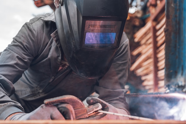 Photo travaux de soudage, man welding in workshop. ferronnerie et étincelles. construction et concept industriel.