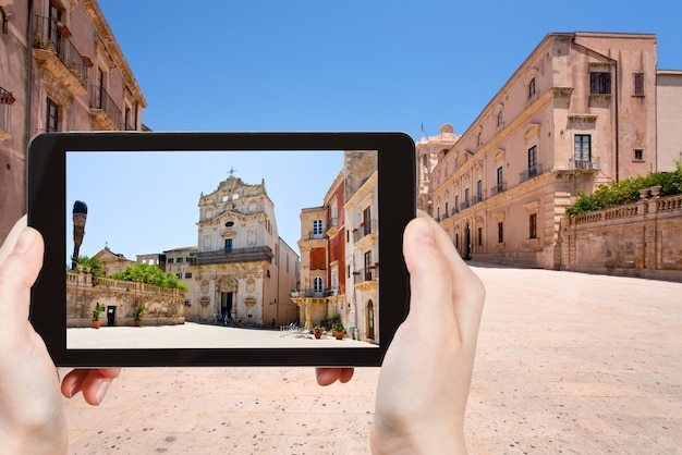 Travel concept - touriste prenant une photo du palais épiscopal médiéval de Syracuse sur un gadget mobile