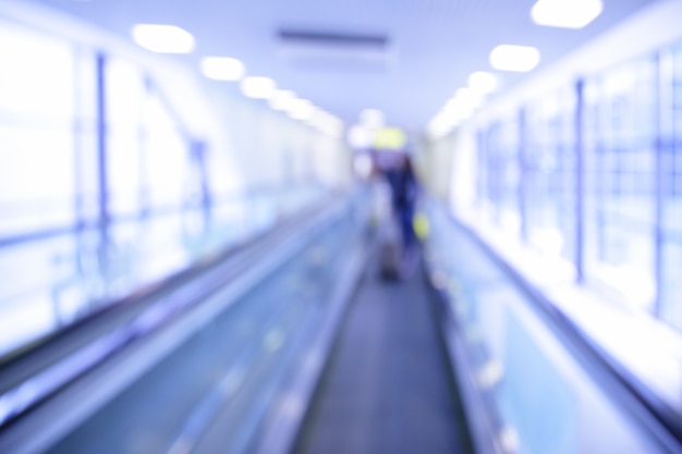 Travelator à l'aéroport flou - arrière-plan abstrait. Tonifié en bleu