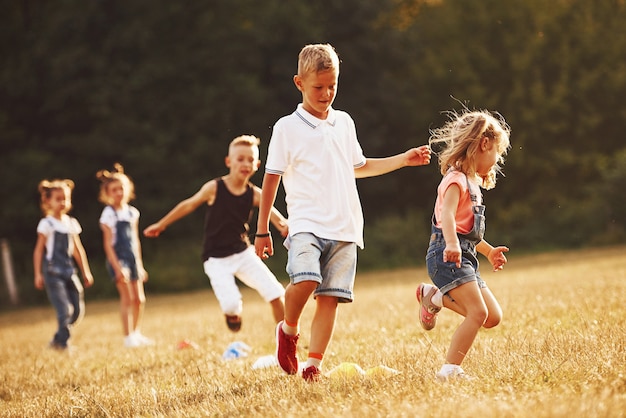 À travers les obstacles. Les enfants courent sur le terrain en journée ensoleillée. Conception d'un mode de vie sain.