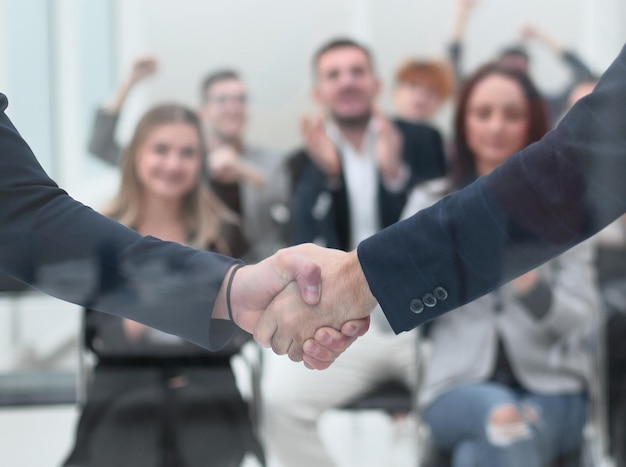 À travers la poignée de main en verre des hommes d'affaires dans le concept de réussite de la salle de conférence