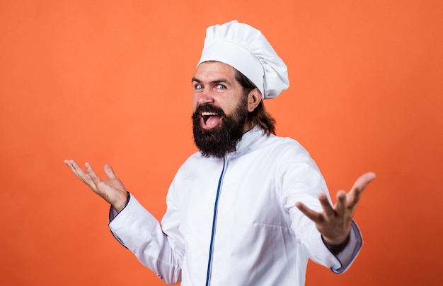 Être un cuisinier masculin affamé prêt à préparer de la nourriture hipster brutal en tablier va cuisiner l'heure des repas pour manger un concept de cuisson heureux de ménage homme barbu mature porter un chapeau de chef