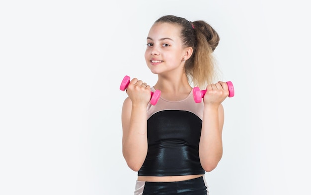 Être puissant petite fille s'entraînant avec des haltères sport et fitness adolescente tenir haltère vêtements de sport et magasin d'équipement mode de vie sain régime pour enfants entraînement enfant dans la salle de gym isolé sur blanc