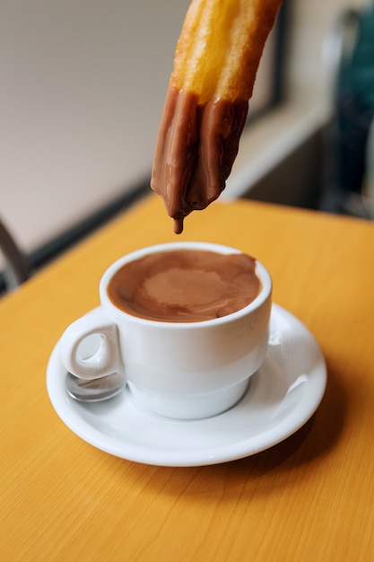 tremper des beignets dans du chocolat chaud