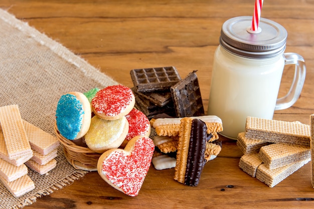 Tremper des biscuits dans du lait, Divers types de biscuits et biscuits, farcis et faits maison avec un verre de lait.